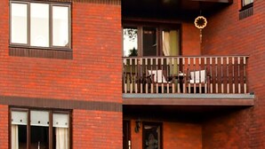 A two-story brick building with a balcony on the upper floor. - Erris Villa (Builth Wells)
