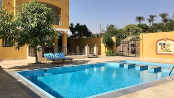 Piscine extérieure, parasols de plage, chaises longues