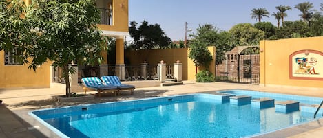 Piscine extérieure, parasols de plage, chaises longues