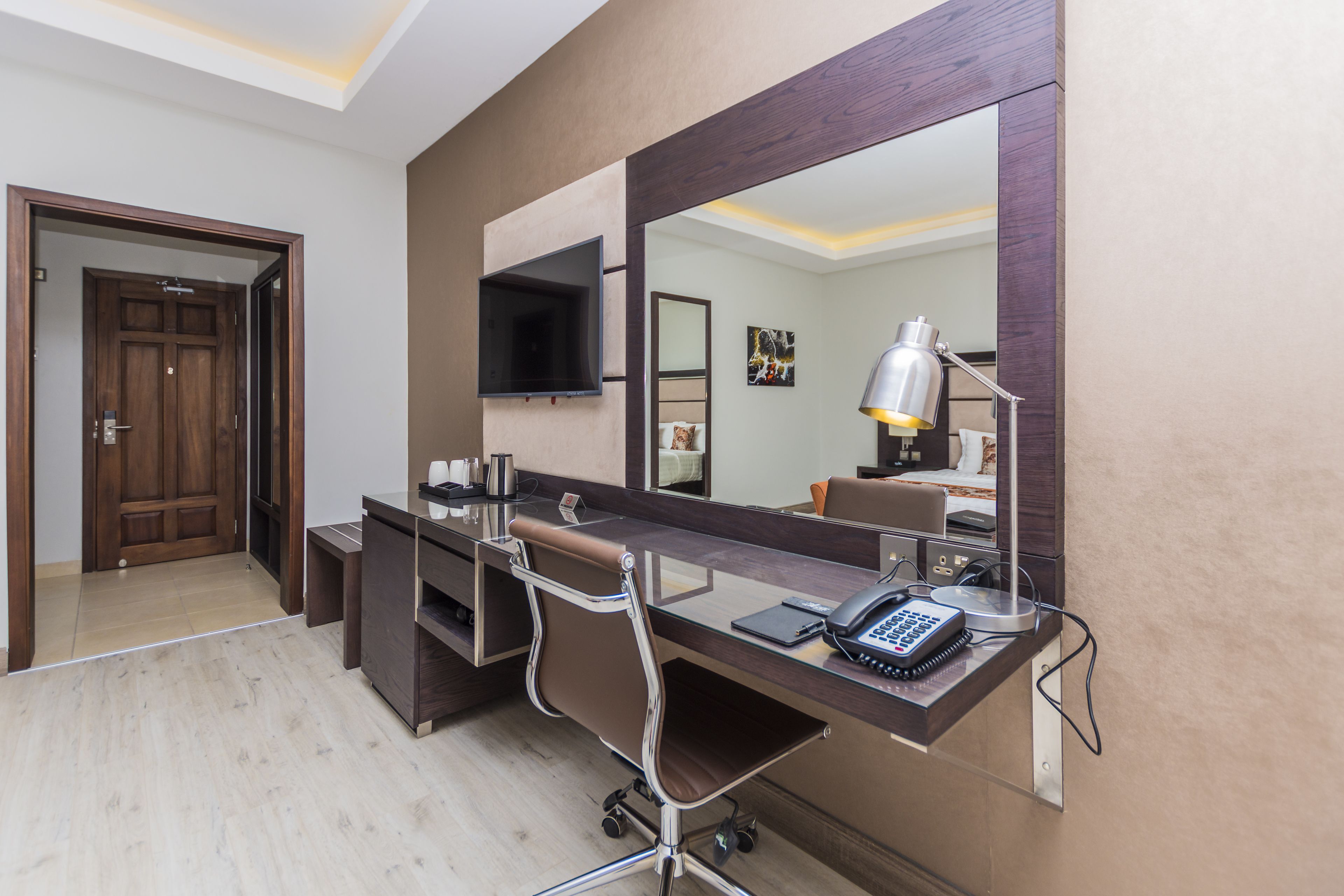 A modern bathroom with a large mirror, a vanity with a sink, and a toilet.