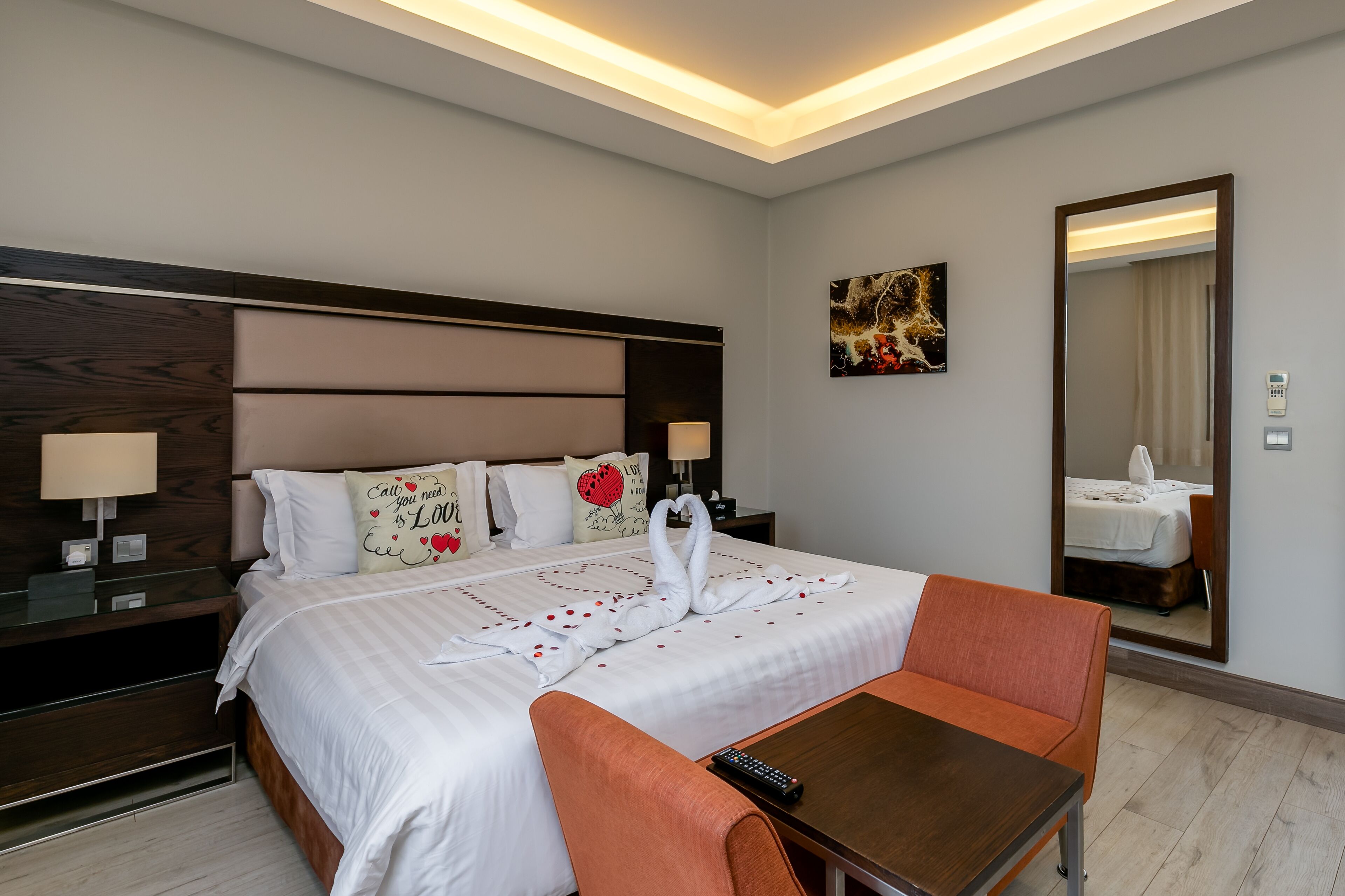 Une chambre d’hôtel avec un grand lit, une table de chevet, une table et une chaise.