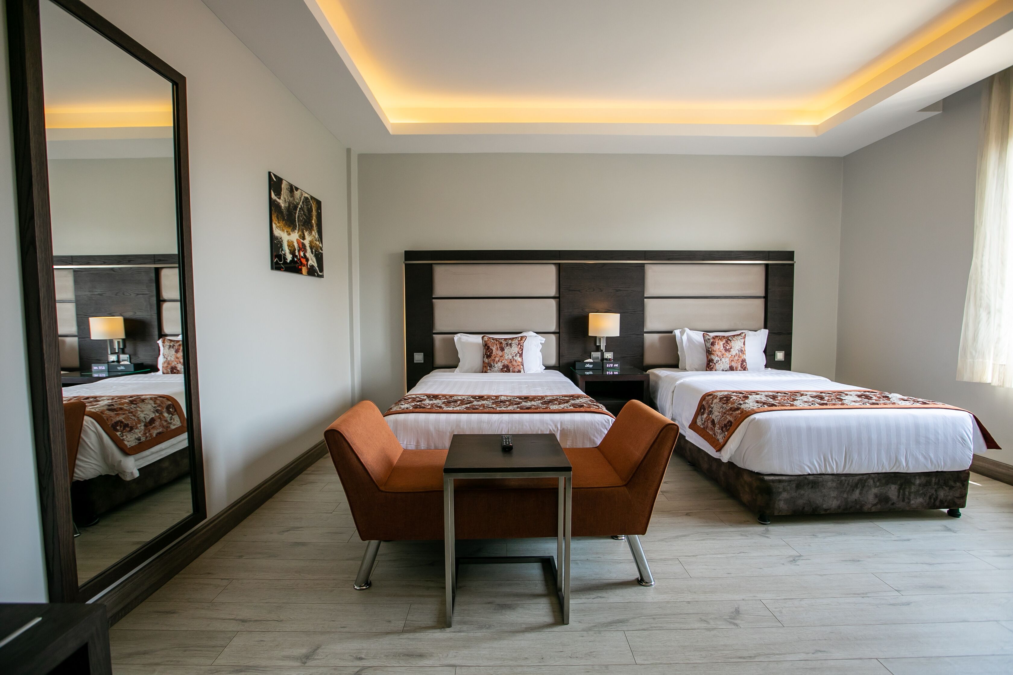 Ein Hotelzimmer mit zwei Betten, einem kleinen Tisch und einem Spiegel.