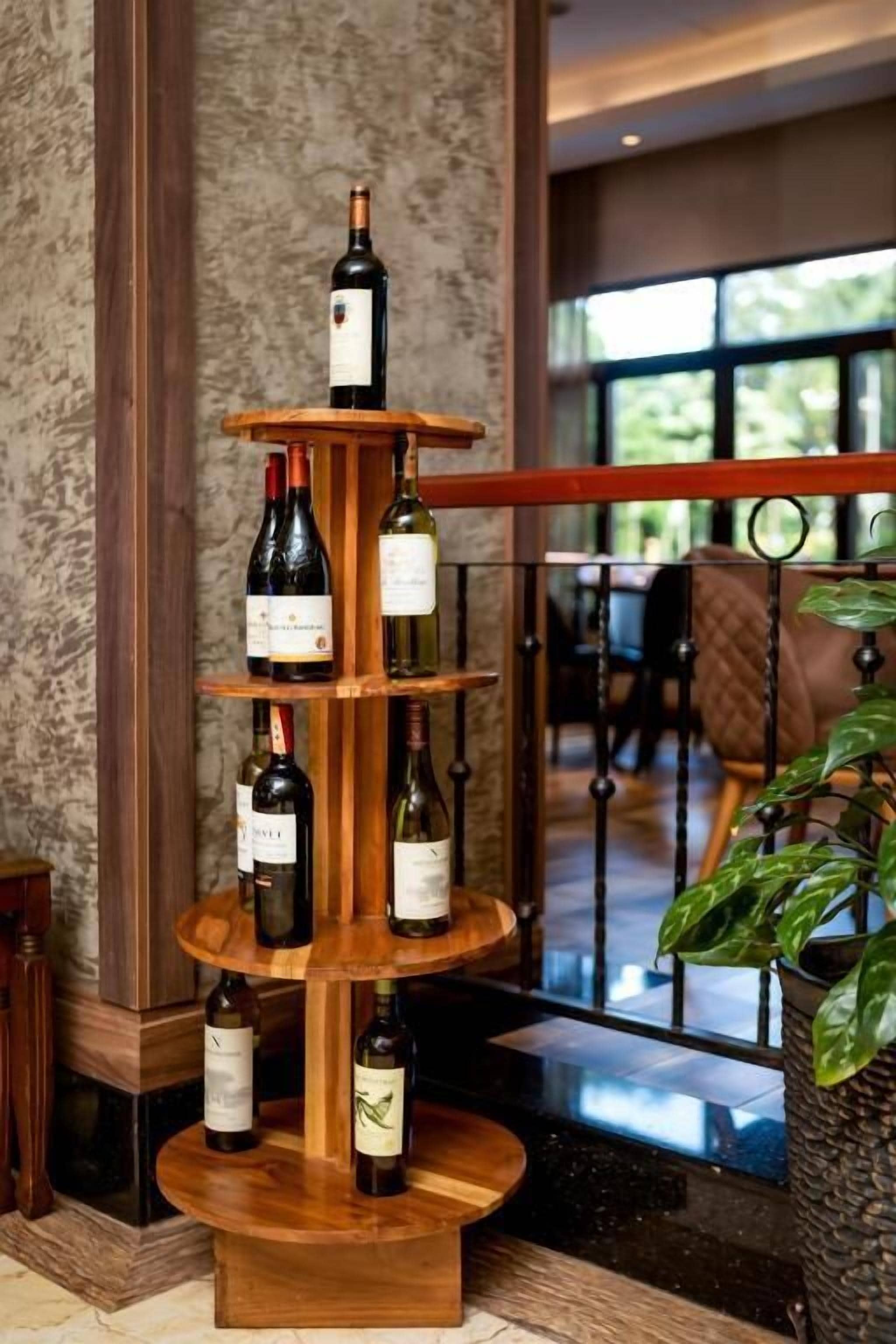 A wine display with multiple bottles on a wooden stand in a hotel lobby.