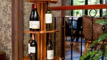 A wine display with multiple bottles on a wooden stand in a hotel lobby.