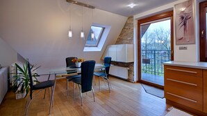 A modern dining area with a glass table, metal chairs, and a potted plant. - Apartament Ogrody Górskie widok na Tatry (Zakopane)