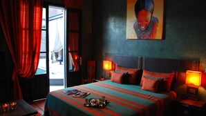 Une chambre d’hôtel avec un grand lit, deux lampes de chevet, un tableau au mur et une fenêtre avec des rideaux.