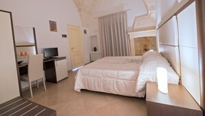 A bedroom with a bed, desk, chair, and a television. - B&B Monte Castello (Villa Castelli)