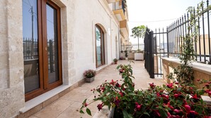 A building with large windows, a balcony with a railing, and potted plants. - B&B Monte Castello (Villa Castelli)
