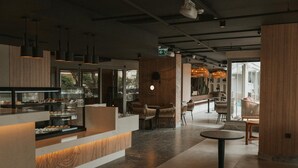 A modern interior with a central counter, seating area, and a view of the outdoors.