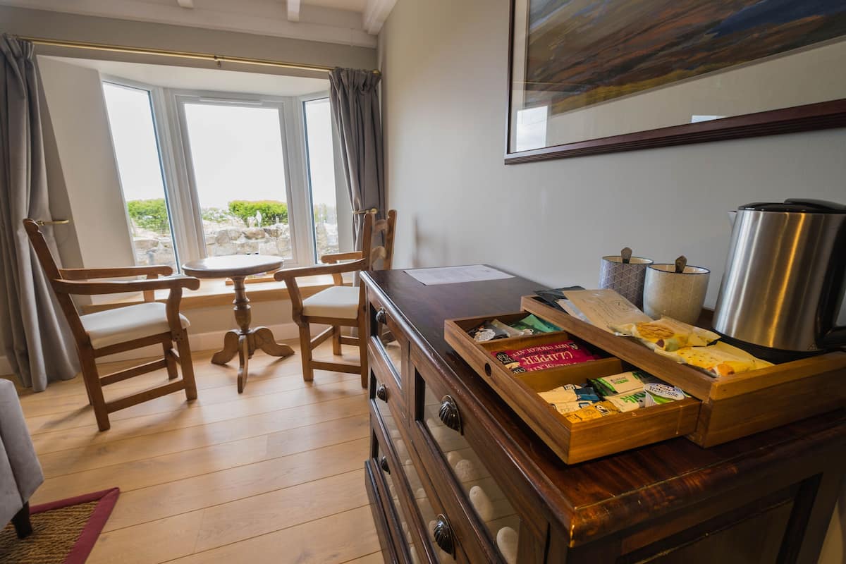 A cozy room with wooden furniture, a dining table, and a coffee station.