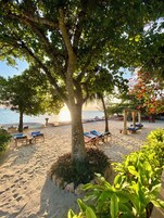 En la playa, arena blanca, sillas reclinables de playa, toallas de playa