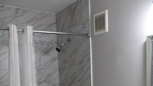 Une salle de bain équipée d’une baignoire, d’un rideau de douche, de toilettes et d’un lavabo.