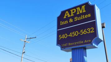Señal de APM Inn & Suites con número de teléfono y dirección.