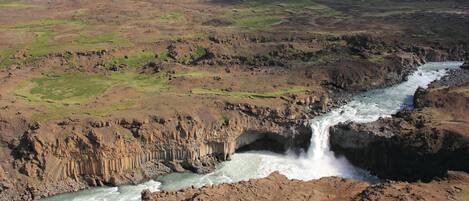 A river flowing through a rugged landscape with a waterfall.