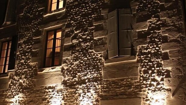 Un edificio de piedra con comedor y mesas al aire libre.