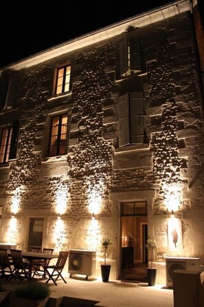 A stone building with a dining area and outdoor seating. - Maison Charles Maurice (Chalais)