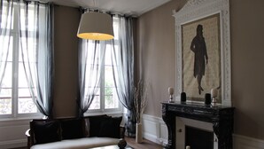 Una habitación con sofá, una mesa, chimenea y un cuadro en la pared.