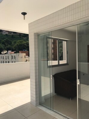 A modern bathroom with a glass shower enclosure, a bathtub, and a window. - Locking Santo Antônio IV (Belo Horizonte)
