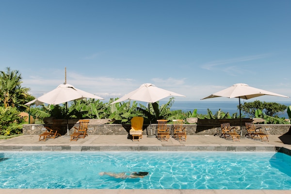 Una piscina al aire libre, sillones reclinables de piscina
