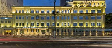 A multi-story hotel with a classic architectural design, featuring a central entrance and uniform window patterns.