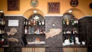 A bar area with a variety of liquor bottles, a fish-shaped decoration, and a menu sign. - Hotel Acapulco (Panama City)