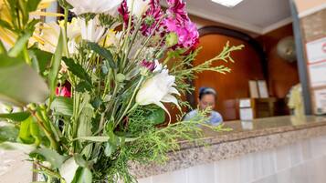 Un área de recepción con un arreglo floral en la mesa.