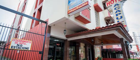 Hotel con un cartel que indica 'No Parking' y 'Servicio 24 horas'.