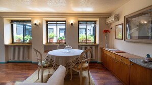 Un comedor con una mesa redonda, sillas, un banco y un armario.