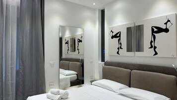 Ein modernes Hotelzimmer mit einem großen Bett, einem Spiegel und Kunstwerken an den Wänden.