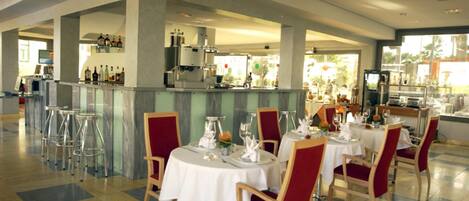 A spacious restaurant with high ceilings, a bar area, and a view of the outdoors.