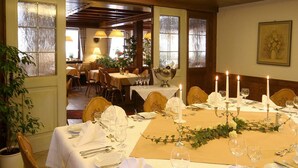 A dining area with tables set for a formal meal, featuring white tablecloths, silverware, and candles. - Hotel Engel (Rheinmunster)