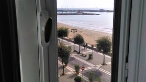 A view through a window of a street with a beach, potted plants, and a no-entry sign. - Déjà Vu (Crotone)