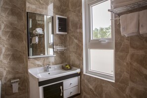 A bathroom with a sink, mirror, towel rack, and a window. - Sao Mai Hotel & Apartment (Ho Chi Minh City)
