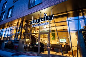 A Staycity apartment hotel with a glass facade, interior lighting, and a visible staircase leading to the entrance. - Staycity Aparthotels, Dublin Castle (Dublin)