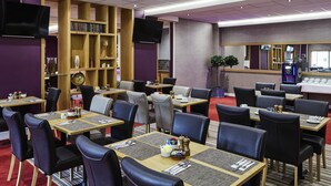 A restaurant with multiple tables, chairs, and a bar area. - Mercure St Helens (St Helens)