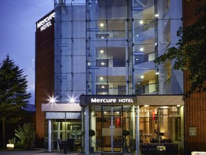 A Mercure Hotel with a modern glass facade, a visible entrance, and a sign indicating 84 bedrooms and conference facilities. - Mercure St Helens (St Helens)