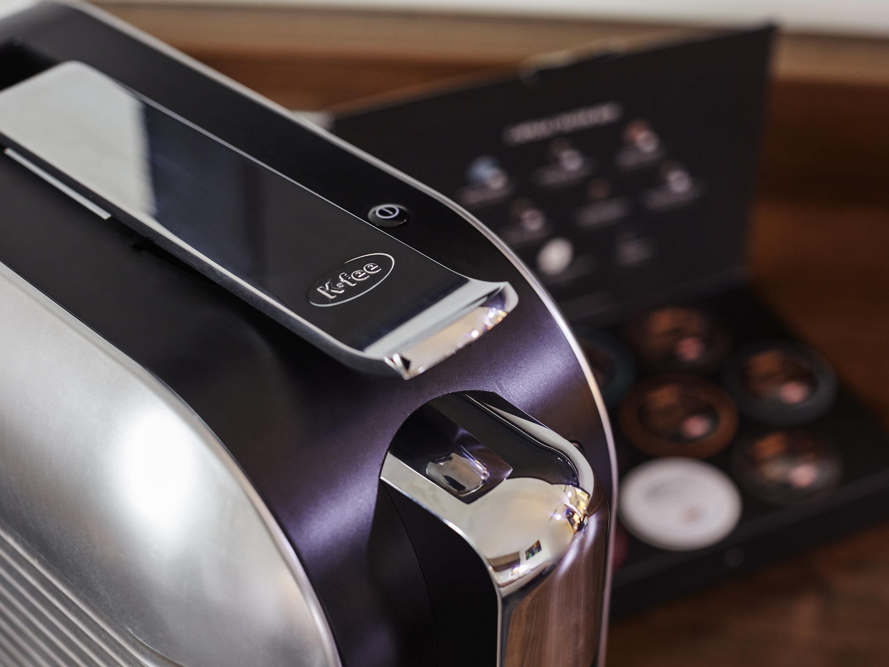 A coffee machine with a control panel and a compartment for coffee pods.