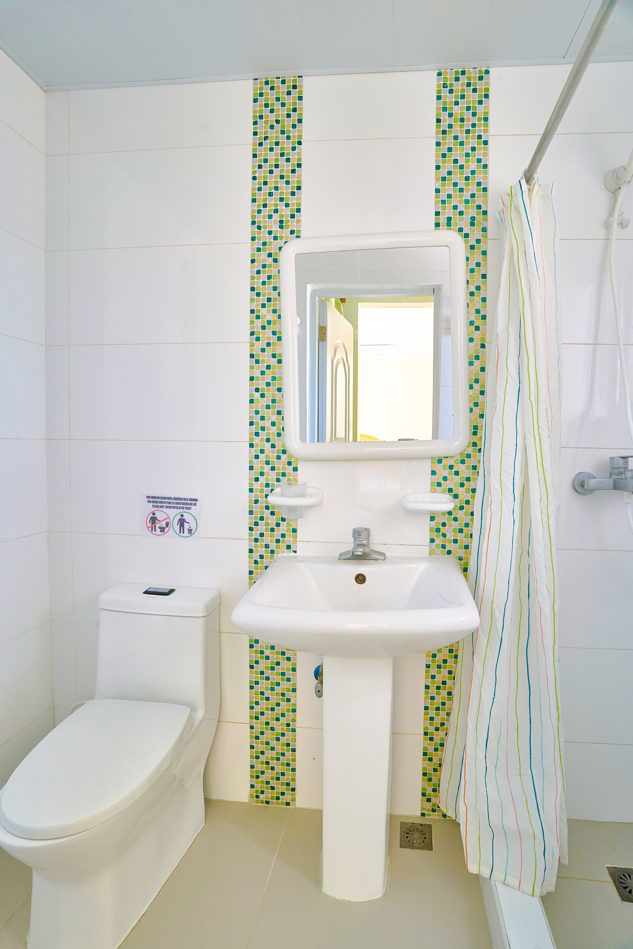 Ein Badezimmer mit Toilette, Waschbecken und Duschvorhang.