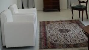 A modern living room with a staircase, white sofas, a wooden cabinet, and a chandelier. - Younique (Sorrento)