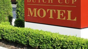 Placa do Sultan Dutch Cup Motel com esquema de cores vermelho e branco e letras douradas.