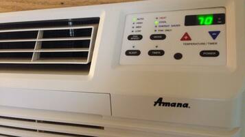 A white air conditioning unit with a digital display, control buttons, and the brand name 'Amana'.