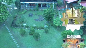 Un edificio grande y rústico con una estructura de madera destacada y un jardín bien cuidado.