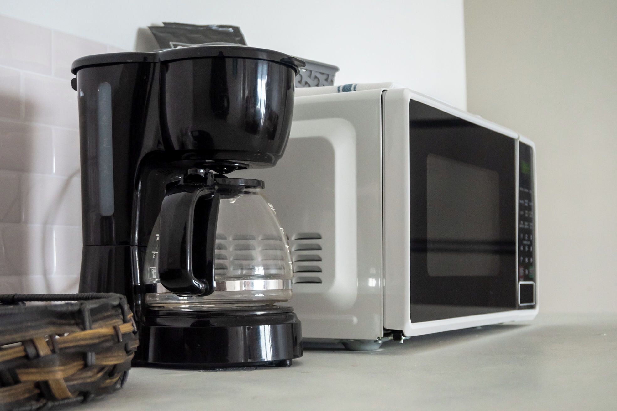 A coffee maker and a microwave on a countertop.
