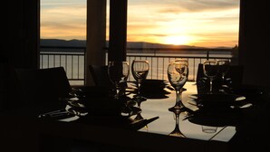 A table set for dining with a view of the sunset over the water. - Apartments Andrea (Omis)