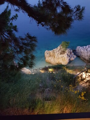 A coastal landscape with a rocky outcrop and a clear view of the sea.
