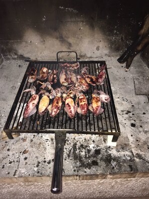 A grill with various meats being cooked.