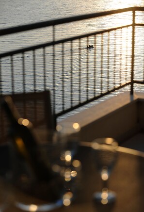 A view of a railing overlooking a body of water, with a blurred foreground suggesting a seating area.
