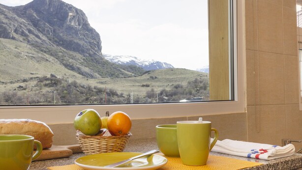 Cozinha com vista para uma paisagem montanhosa pela janela.