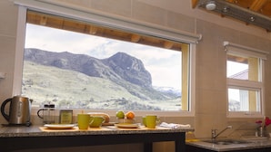 Cozinha com uma grande janela com vista para uma paisagem montanhosa.