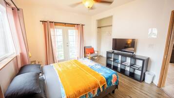 Une chambre à coucher avec un lit, une télévision, un bureau et une chaise.